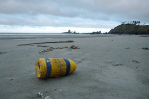 Lost crab buoy on sand at low tide, cloudy skies