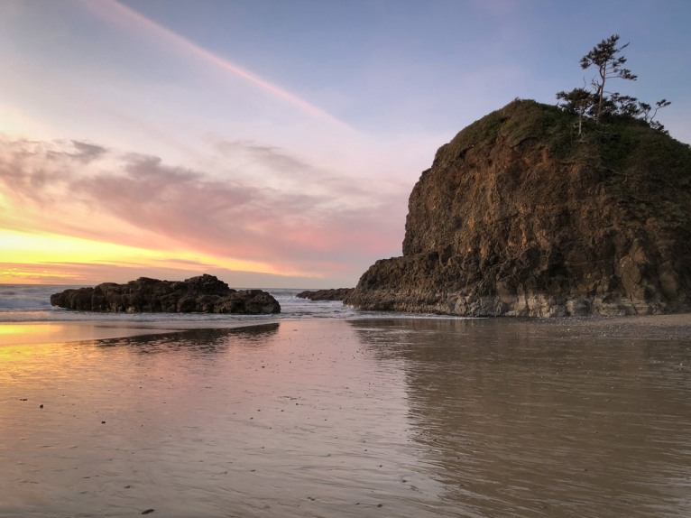 A sunset low tide reveals a sandy beach